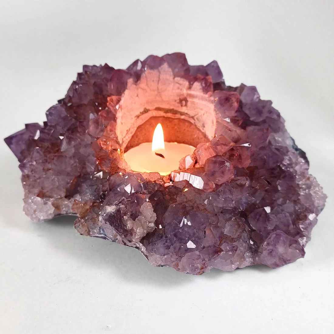 Rough Amethyst Cluster Candle Holder features raw crystal points that reflect candlelight beautifully.