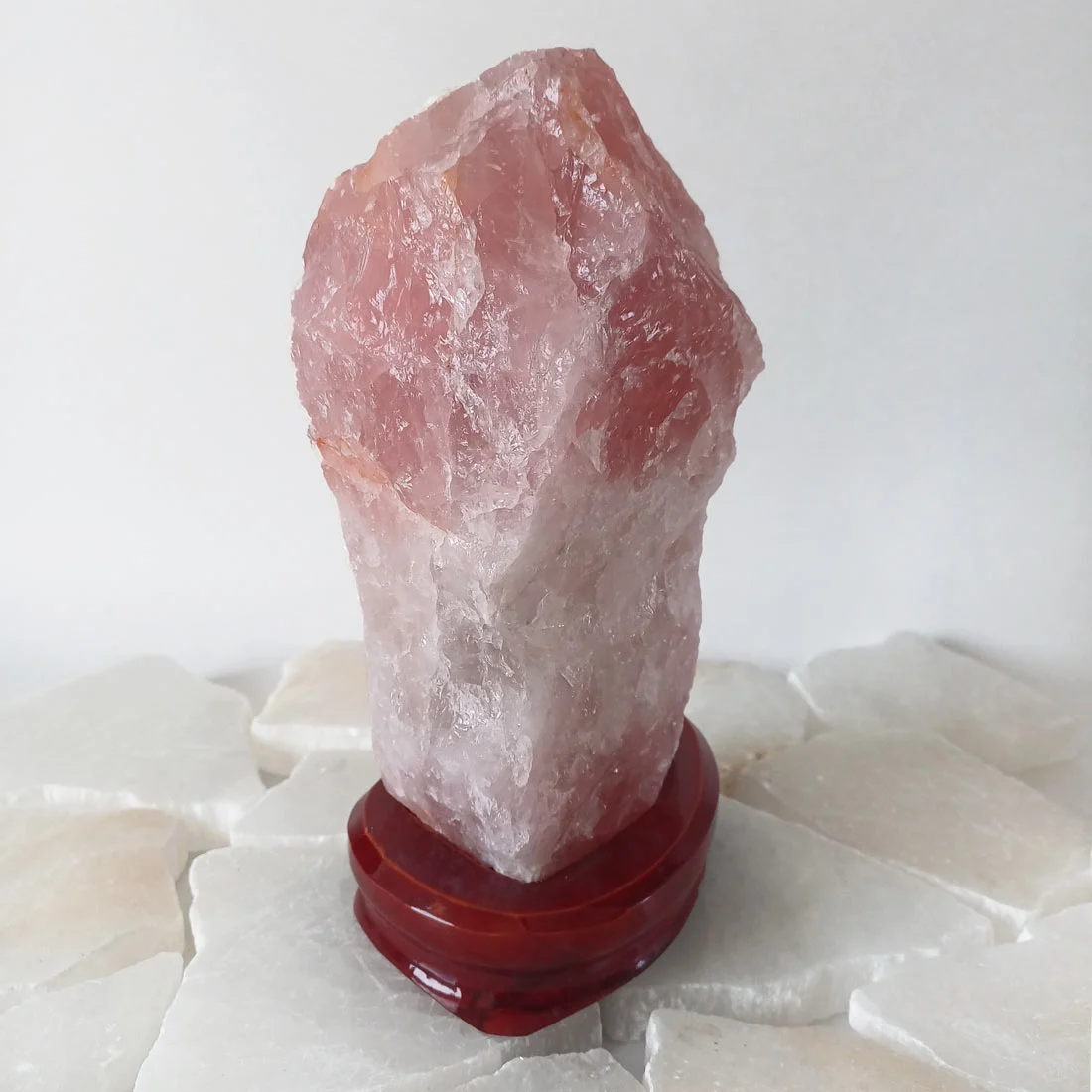 Natural Rose Quartz crystal with soft pink tones displayed on a wooden base, rose quartz cyprus