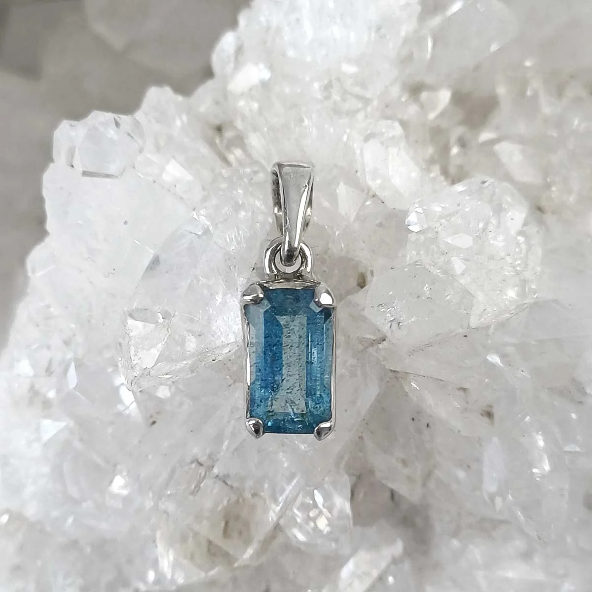 Small rectangular Aquamarine pendant in 925 sterling silver showing translucent light blue crystal.