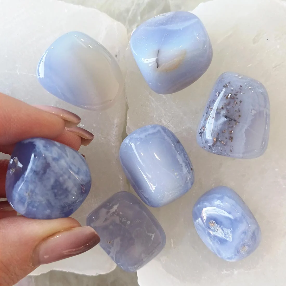 Polished Blue Lace Agate tumbled stone with soft blue and white banding, natural crystal known for calming energy and communication support.