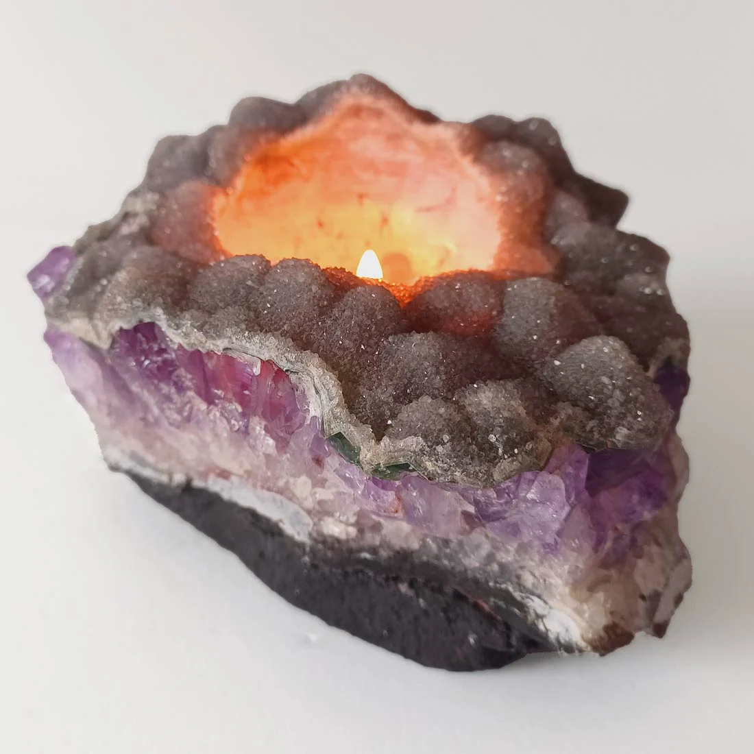 Amethyst crystal candle holder with natural druzy quartz formation. This piece combines raw amethyst with a secondary druzy layer, shaped to hold a tealight.