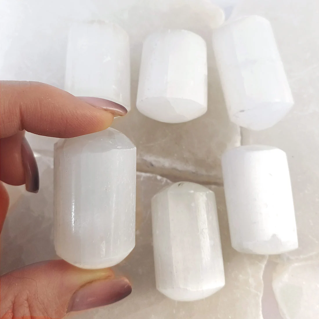 Small polished Selenite tumbled stone with soft white glow and smooth surface, natural crystal for clarity and energy cleansing.