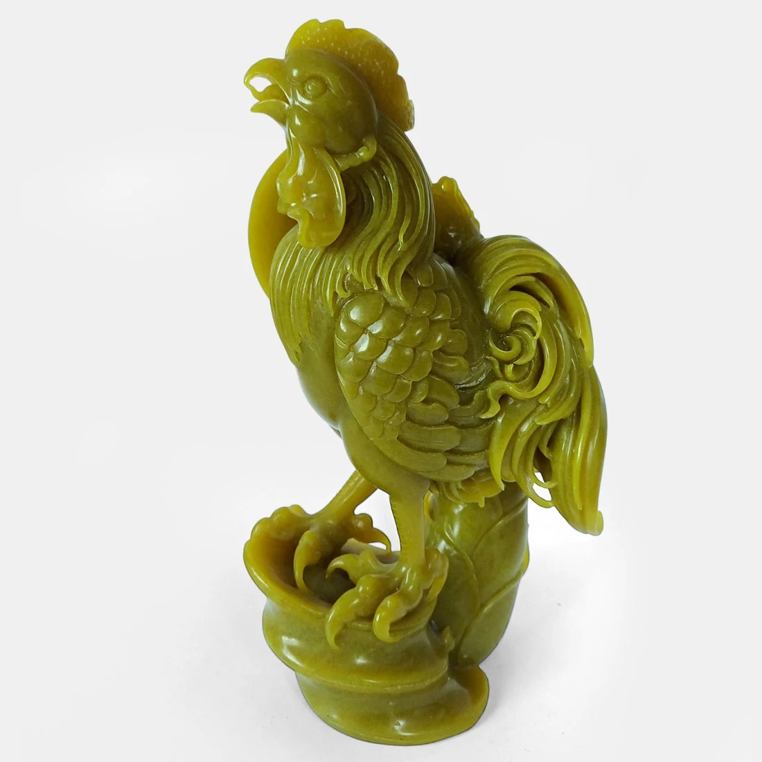 Museum quality hand-carved serpentine rooster sculpture with intricate feather detailing and polished yellow-green stone finish.