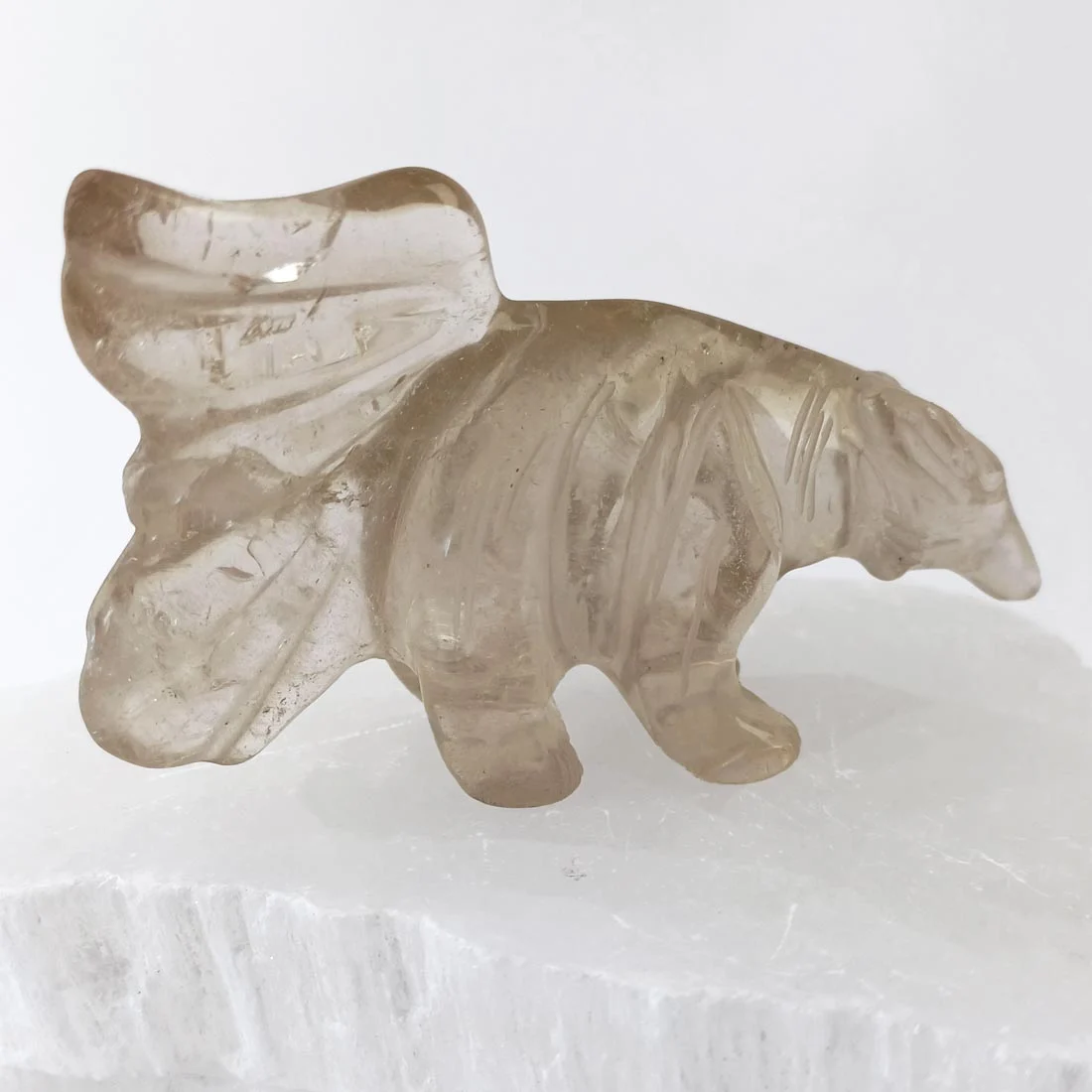 Hand-carved smoky quartz anteater with natural inclusions and soft transparency