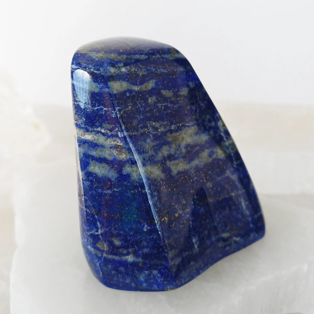Polished self-standing Lapis Lazuli slice from Pakistan with deep blue color and natural pyrite inclusions.