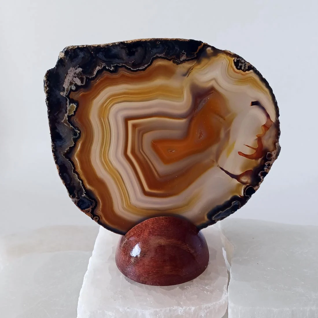 Natural agate slice rock on a removable wooden base.