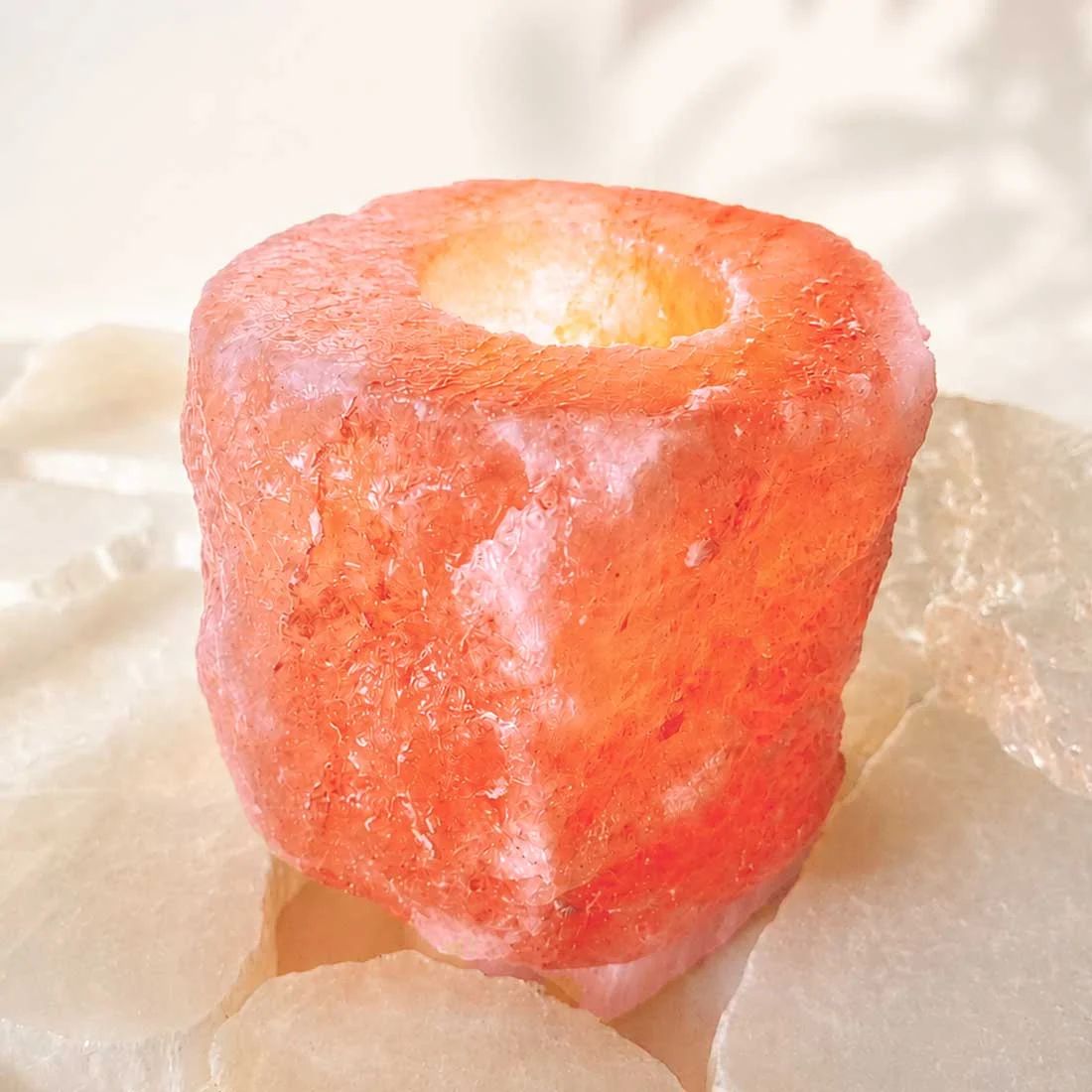 Natural Himalayan Salt Candle Holder carved from genuine Himalayan salt crystal with a warm amber glow from a tealight candle.