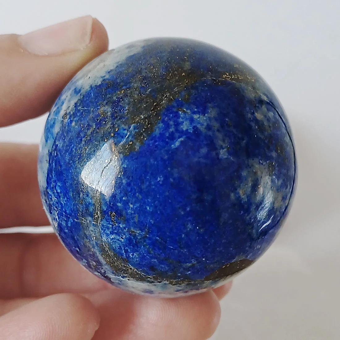 Natural polished Lapis Lazuli sphere with deep blue colour and natural pyrite inclusions.