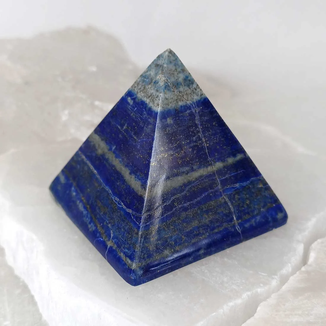 Polished Lapis Lazuli pyramid with deep blue color and natural pyrite inclusions.