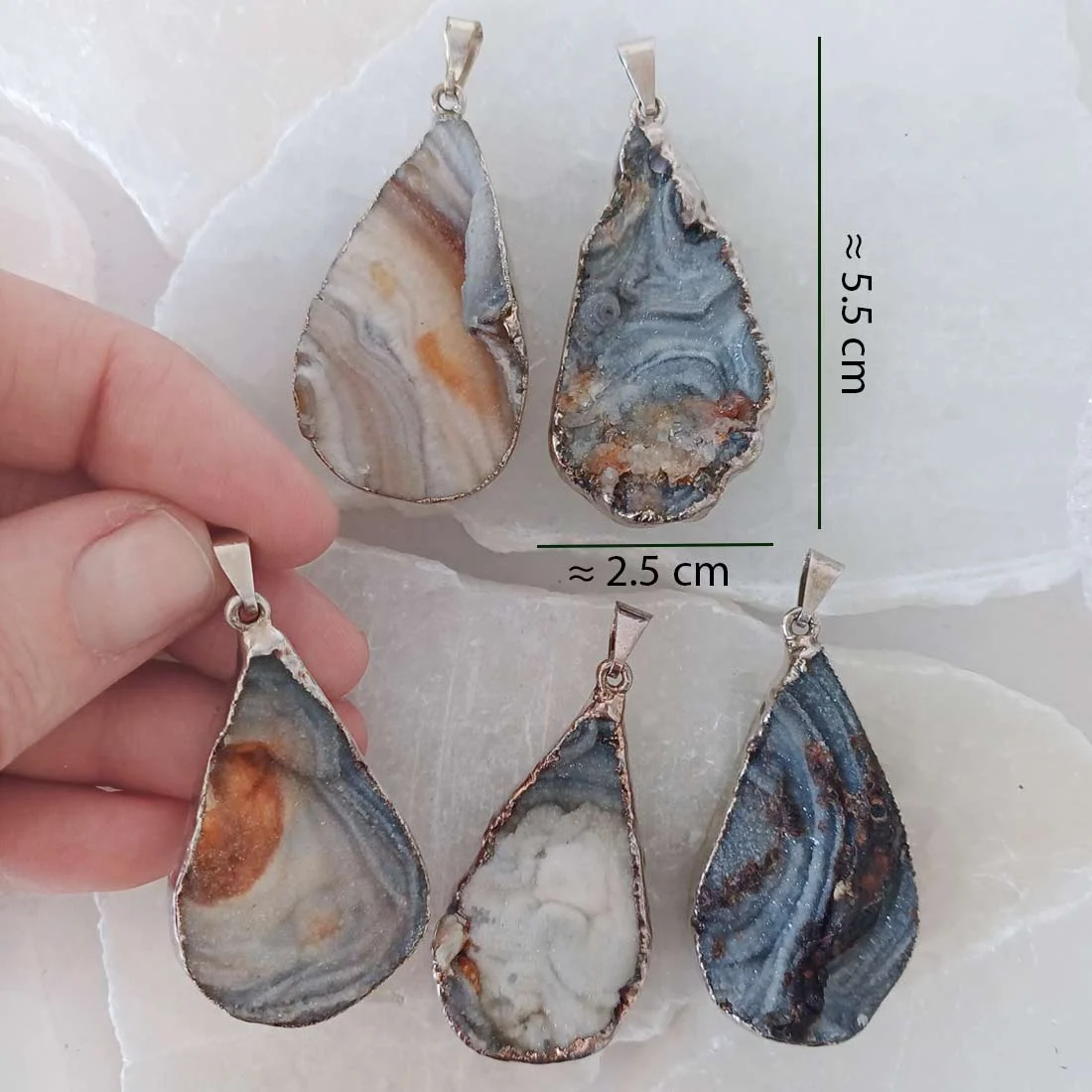 Natural rough Chalcedony slice pendant with metallic frame featuring grey, white and earthy banded patterns.