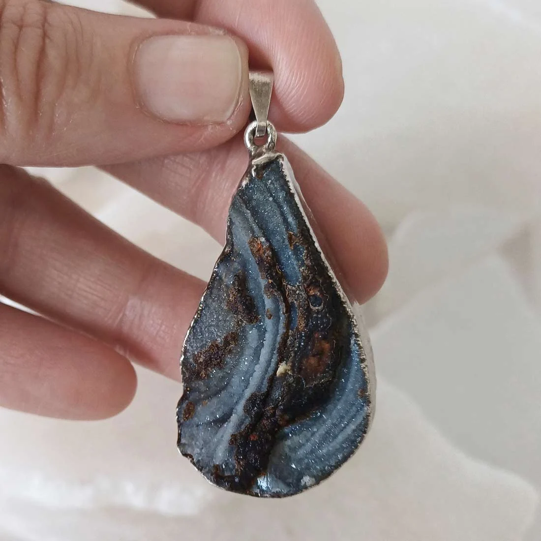 Natural rough Chalcedony slice pendant with metallic frame featuring grey, white and earthy banded patterns.