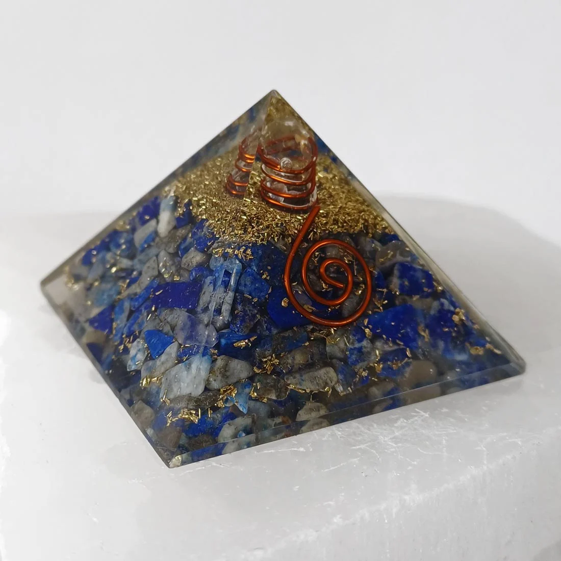 Pyramid Orgonite Lapis Lazuli handmade crystal pyramid with blue lapis lazuli pieces, resin, and metal shavings inside.