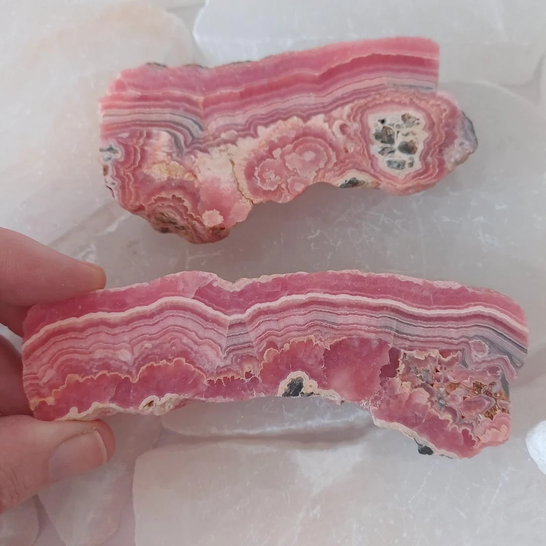 Natural rhodochrosite mineral slice with pink and white banding