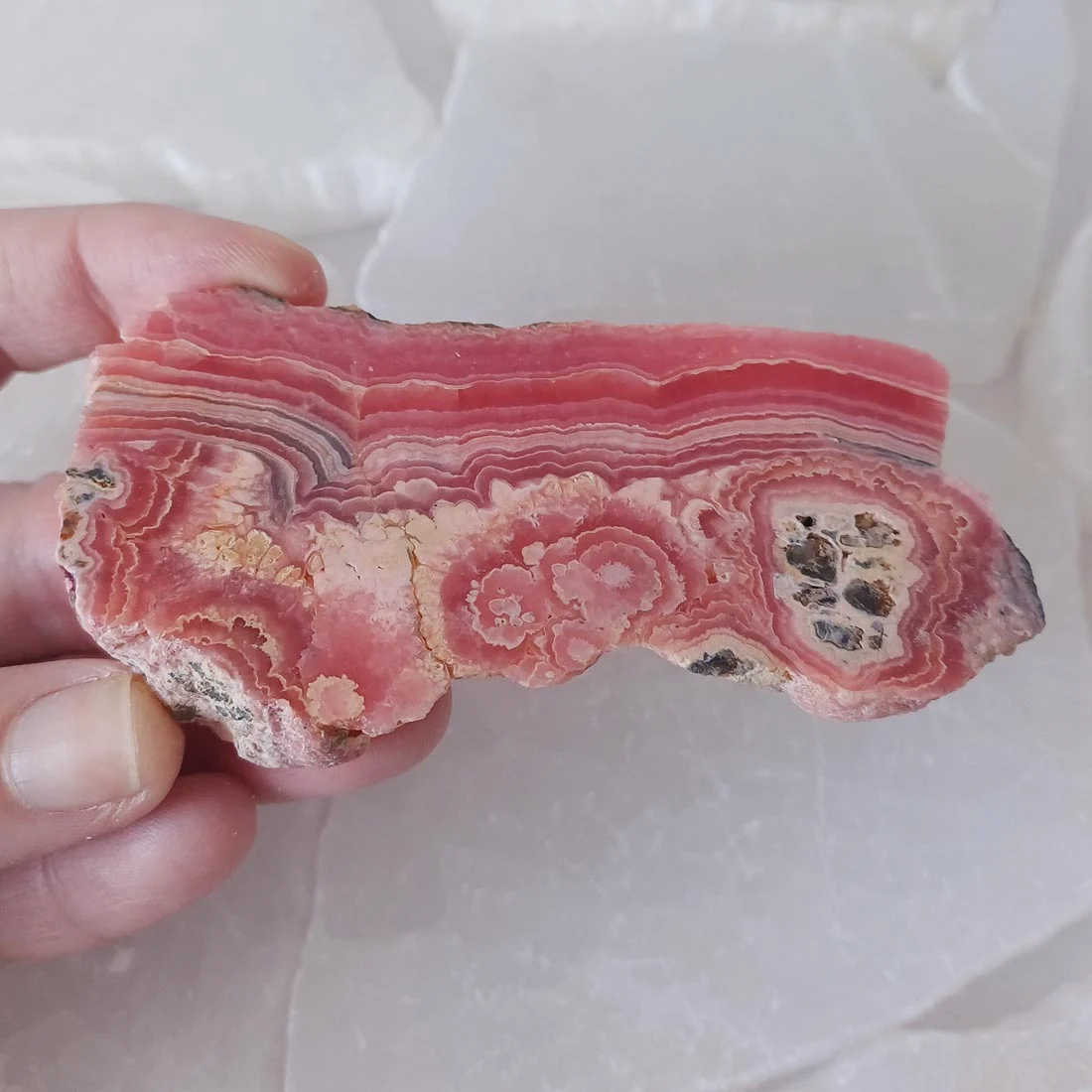 Natural rhodochrosite mineral slice with pink and white banding