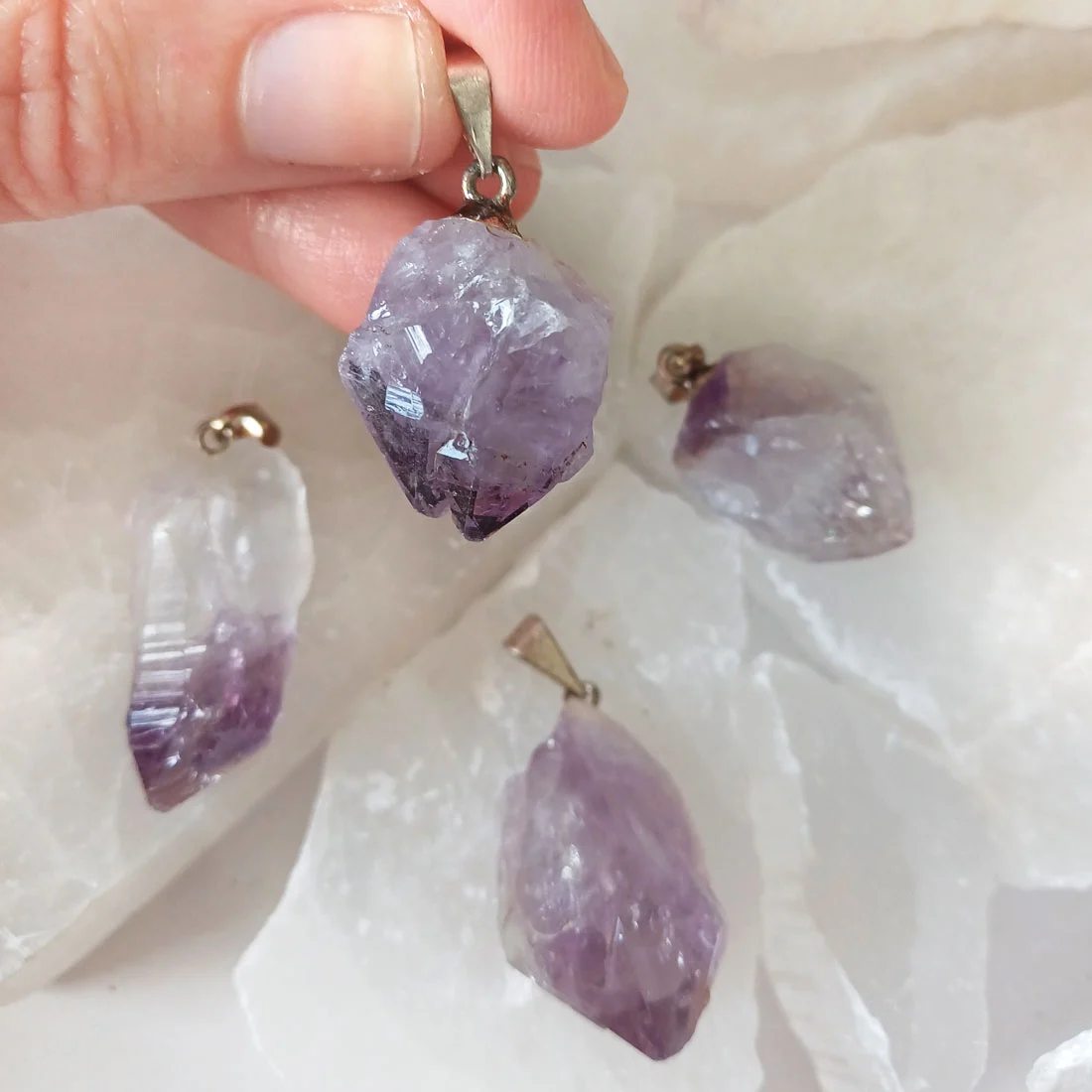 Natural Amethyst rough point pendants with metallic hooks showing purple crystal formations